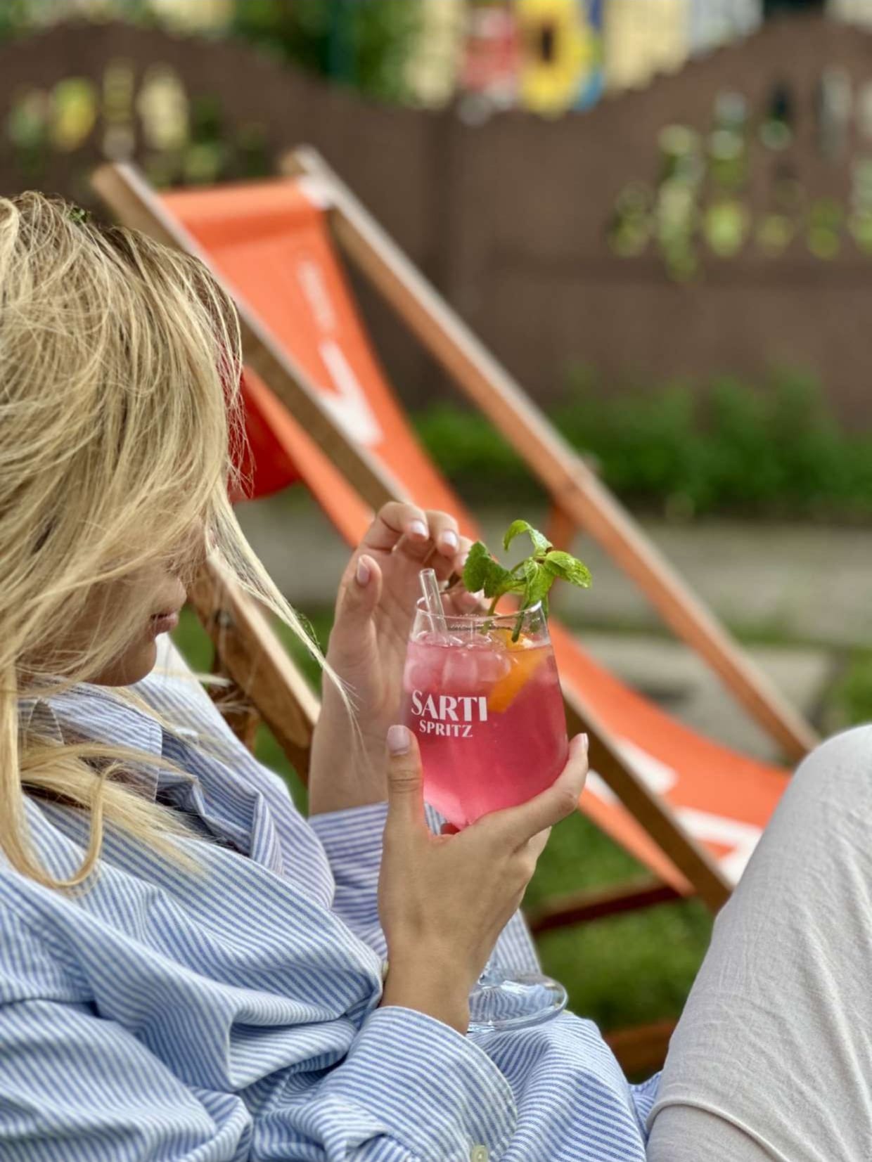 Gast mit Spritz im Liegestuhl auf der Terrasse